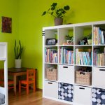 White bookcase against a green wall in a nursery