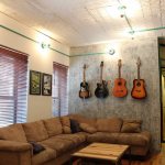 Гитары на бетонной стене в квартире мужчины